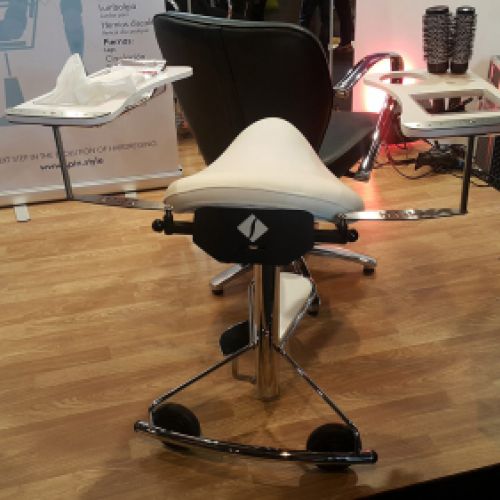 Imagen de silla y banqueta metálicas en interior de peluquería